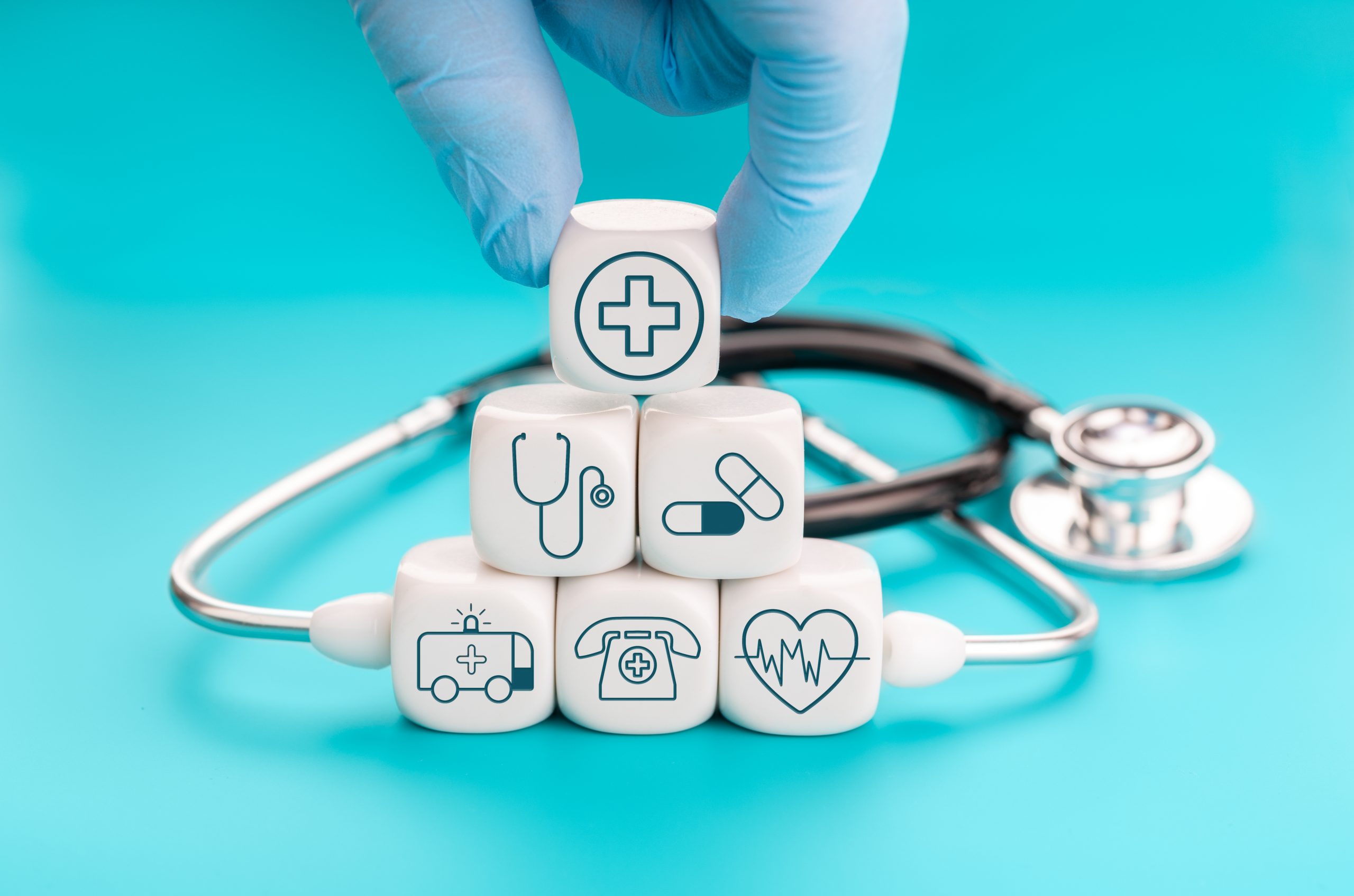 Health insurance concept. Medical symbols on cube shape blocks and Hand holding a block with healthcare medical icon